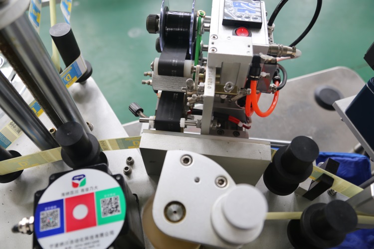 Begi tanta automatikoak botilak eranskailuen etiketatze-makina inguratzen ditu Begi tanta automatikoak botilak eranskailuen etiketatze-makina inguratzen ditu